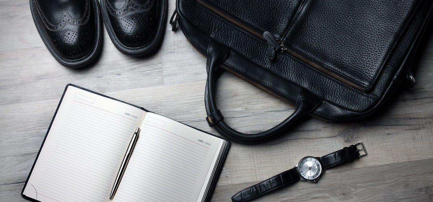 scarpe, orologio, borsa e blocco note aperto